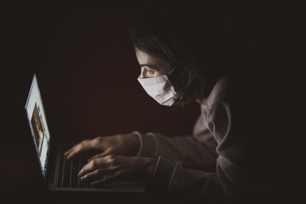 555电影内容编辑在电脑前整理长文选题，屏幕上并排打开多个公开资料页面，桌上放着薄荷绿色的便签纸，呈现内容创作的工作状态